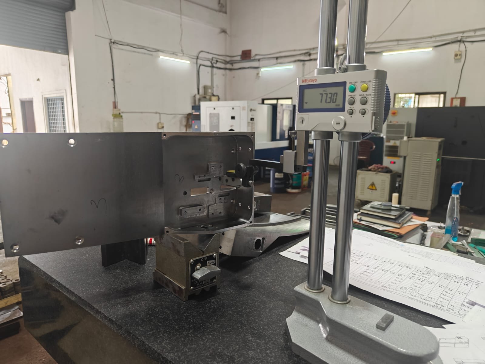 Digital height gauge inspecting a machined component on a granite table